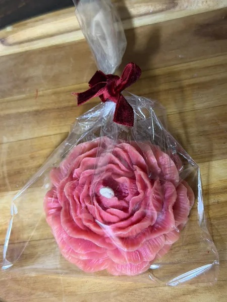Vela peonía rosa envuelta en bolsa transparente con moño vino